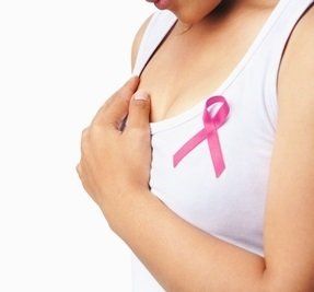 Woman wearing a pink ribbon in support of breast cancer awareness. 